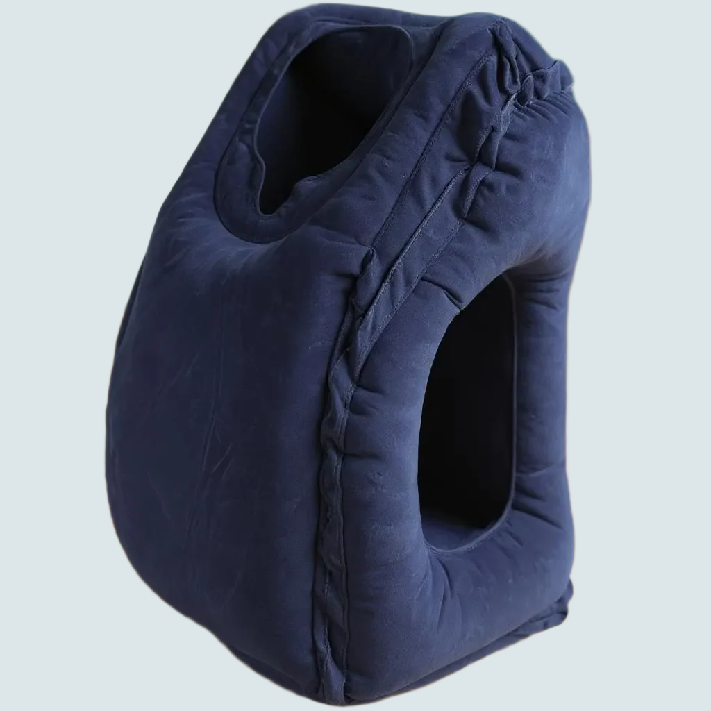 Navy blue Napnook inflatable travel pillow for airplane naps on a light gray background